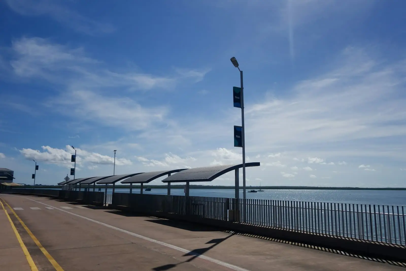 Darwin waterfront path with shade shelters under a bright blue sky
