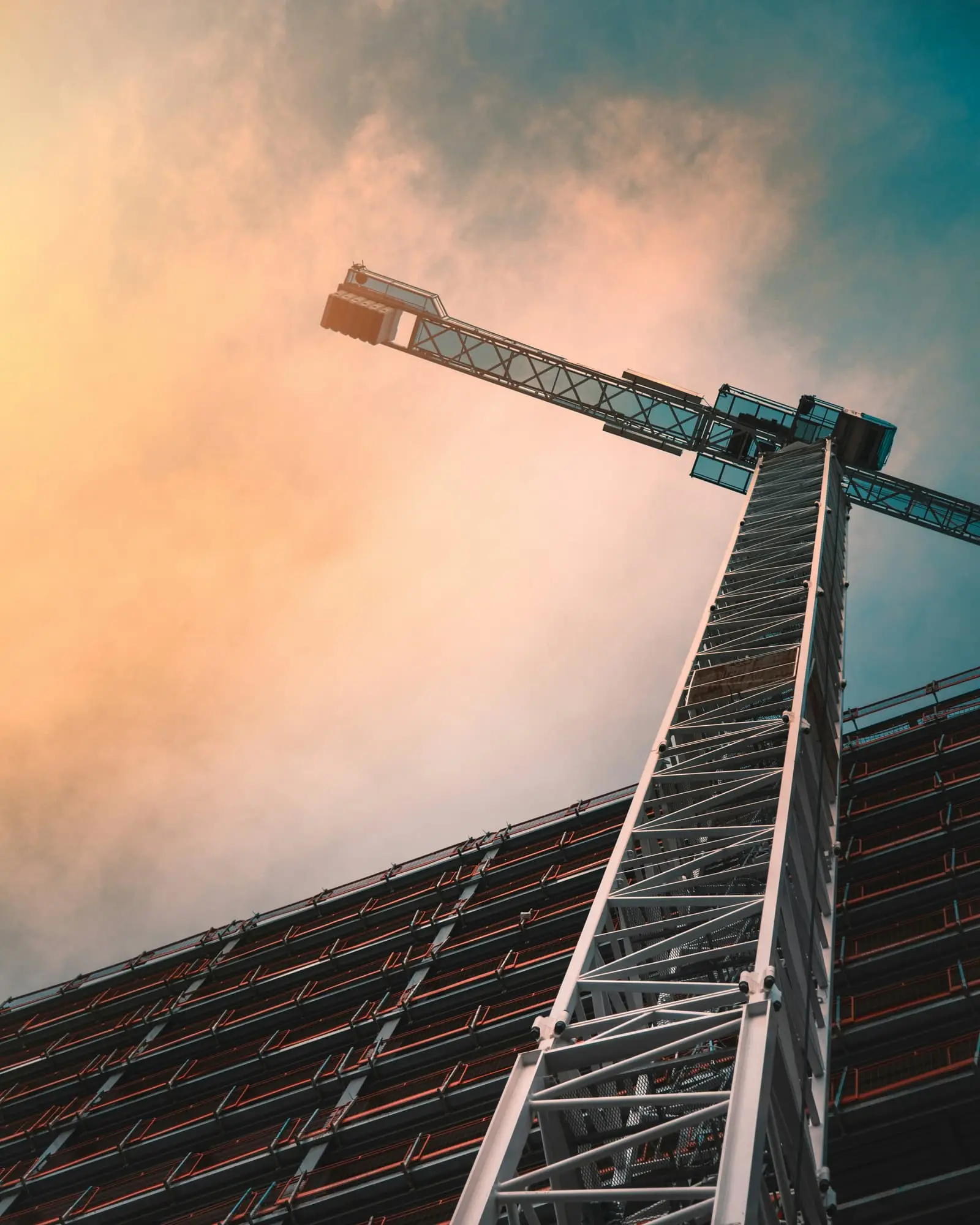 Low angle view of a grey tower crane at a construction site