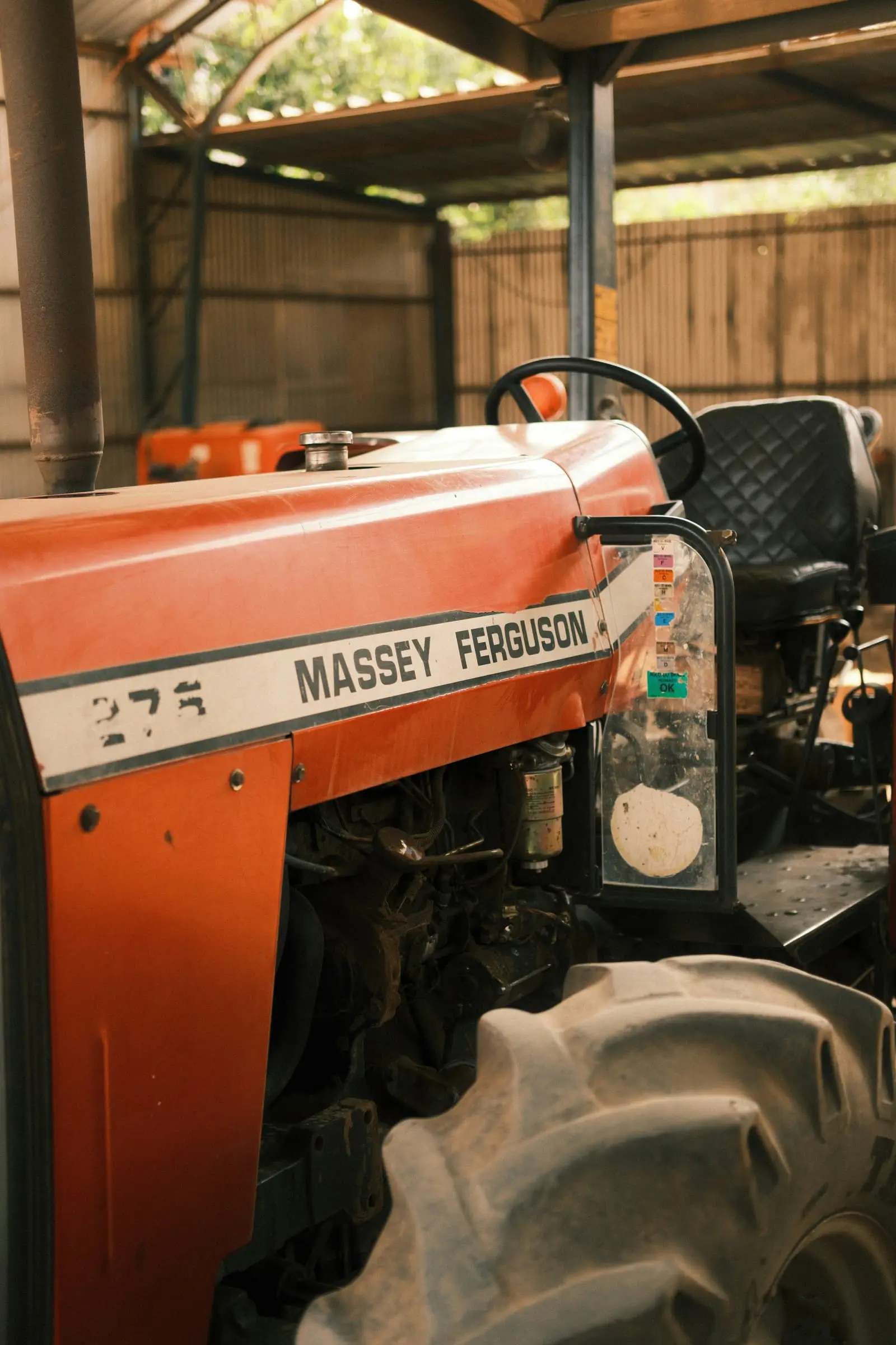 Orange tractor parked inside a garage shed