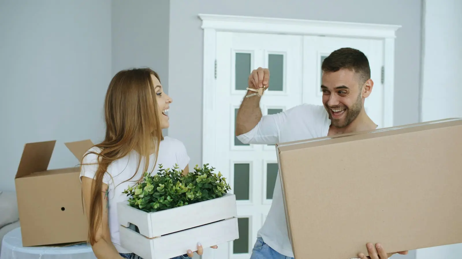 Couple smiling happily as they move into their new home