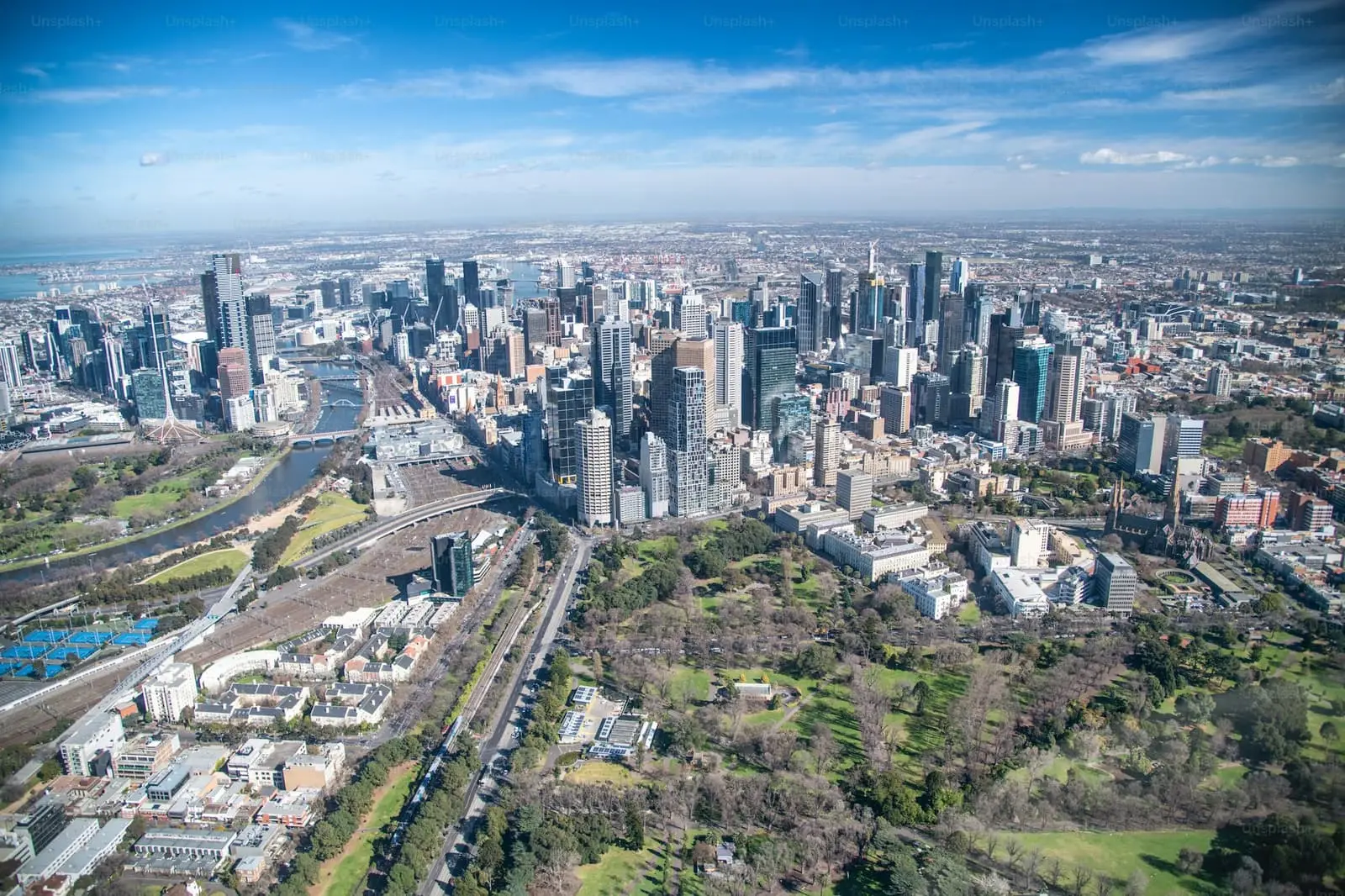Aerial view of Melbourne city skyline, gardens and the Yarra River on a clear day