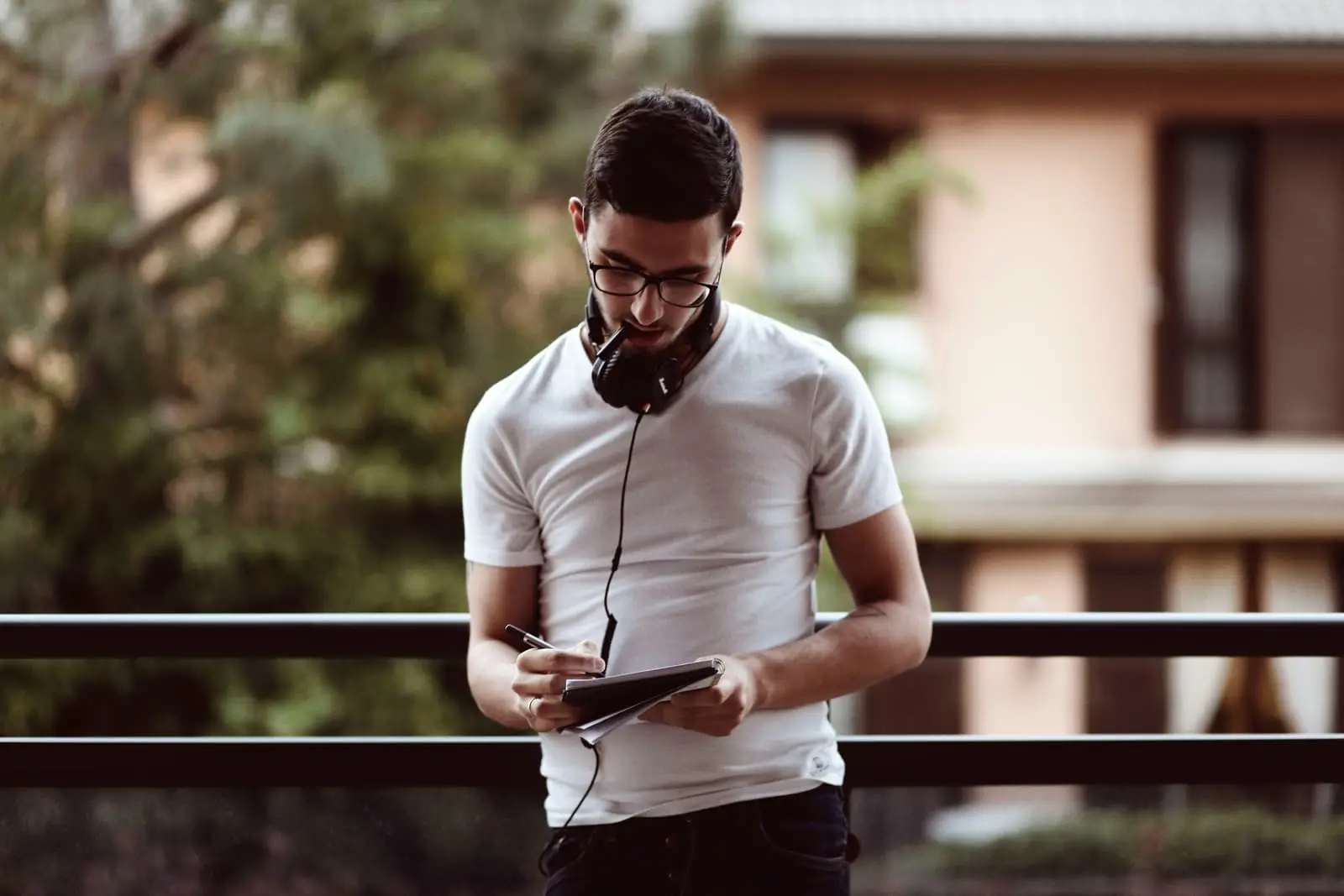Man standing outside holding a pen and notebook