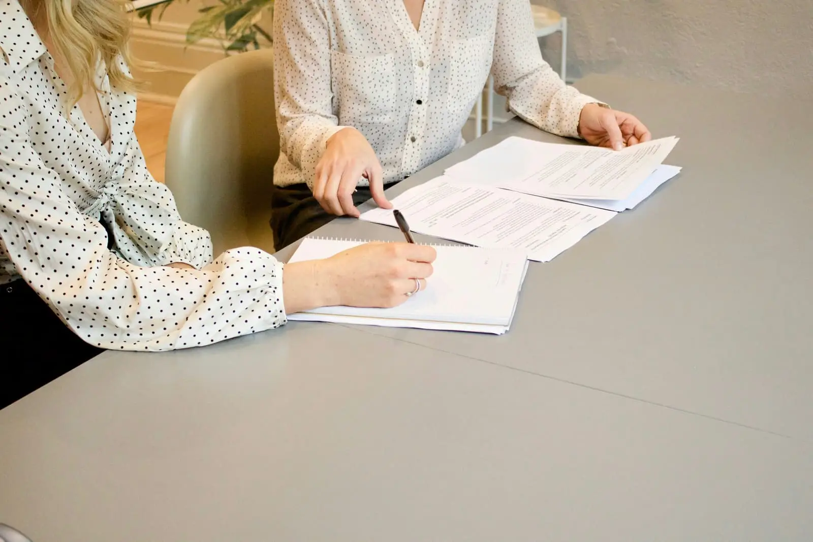 Woman signing documents on paper at a desk