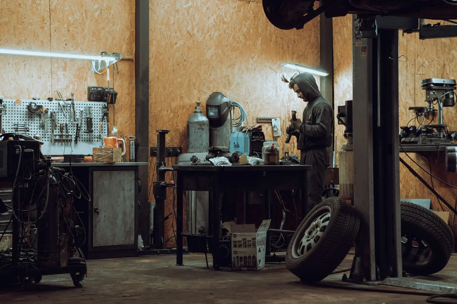 Mechanic working on a machine inside a garage workshop